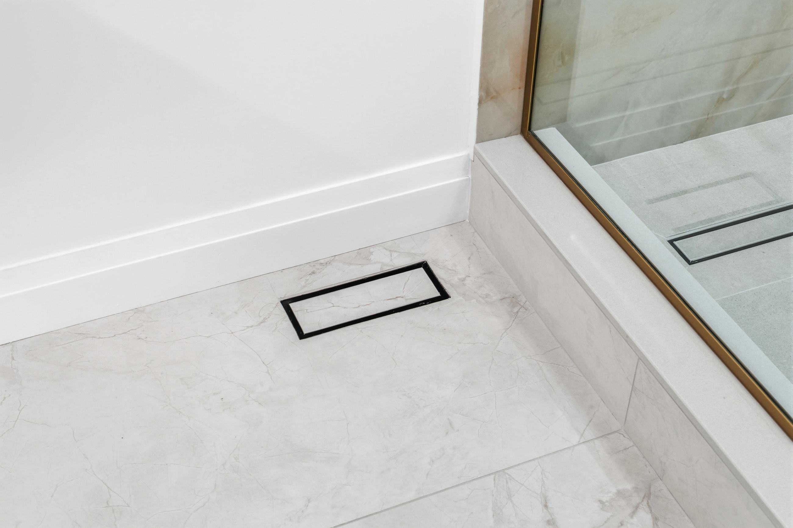 A floor vent tiled to match, set flush into the stone so the pattern runs through it.