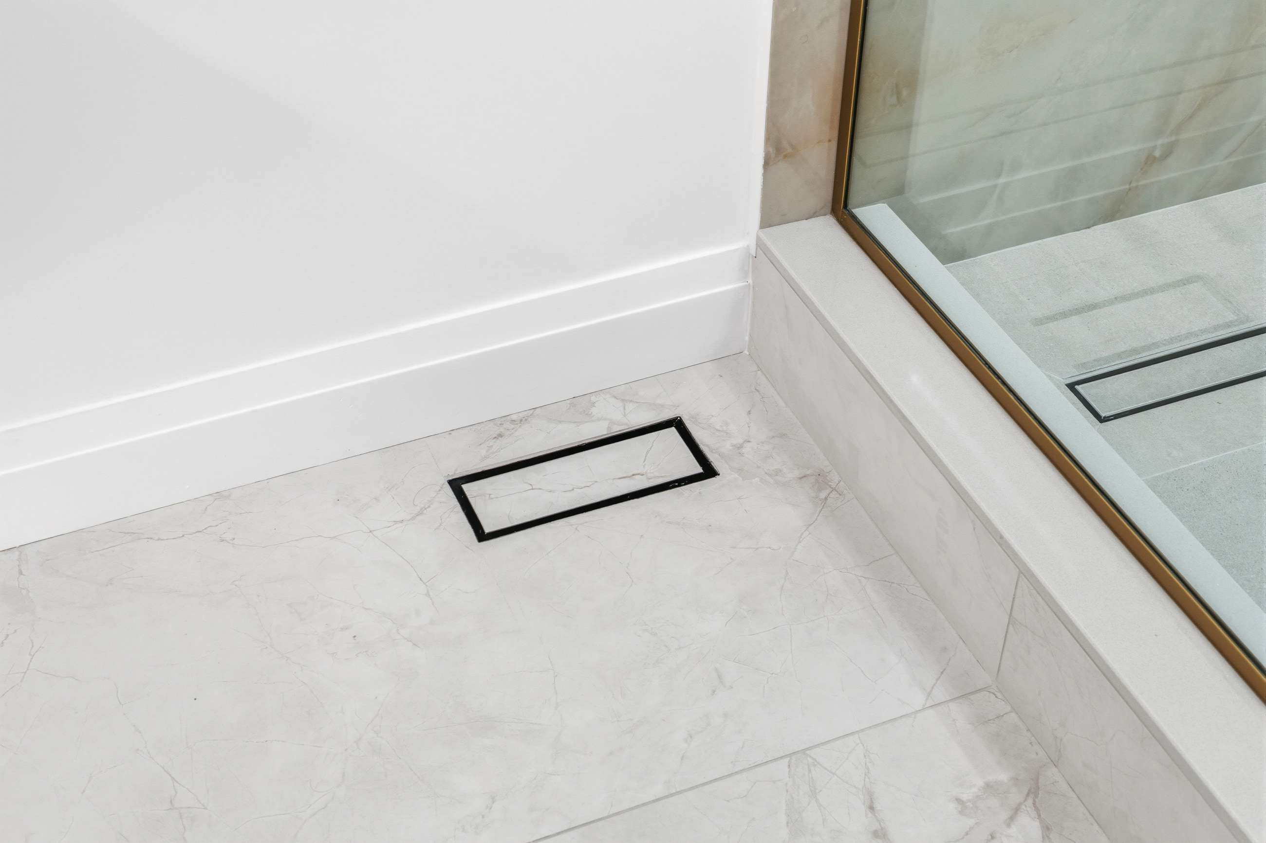 A floor vent tiled to match, set flush into the stone so the pattern runs through it.