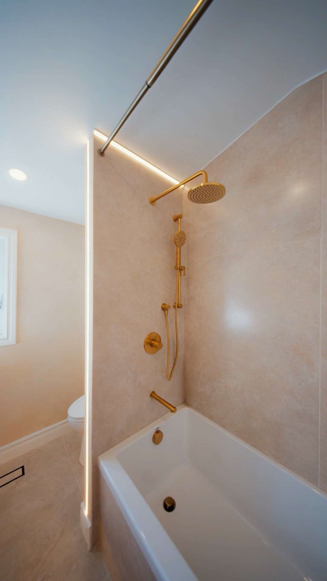 After: a new tub with a rain head and hand shower, a light line running up the wall and along the ceiling.
