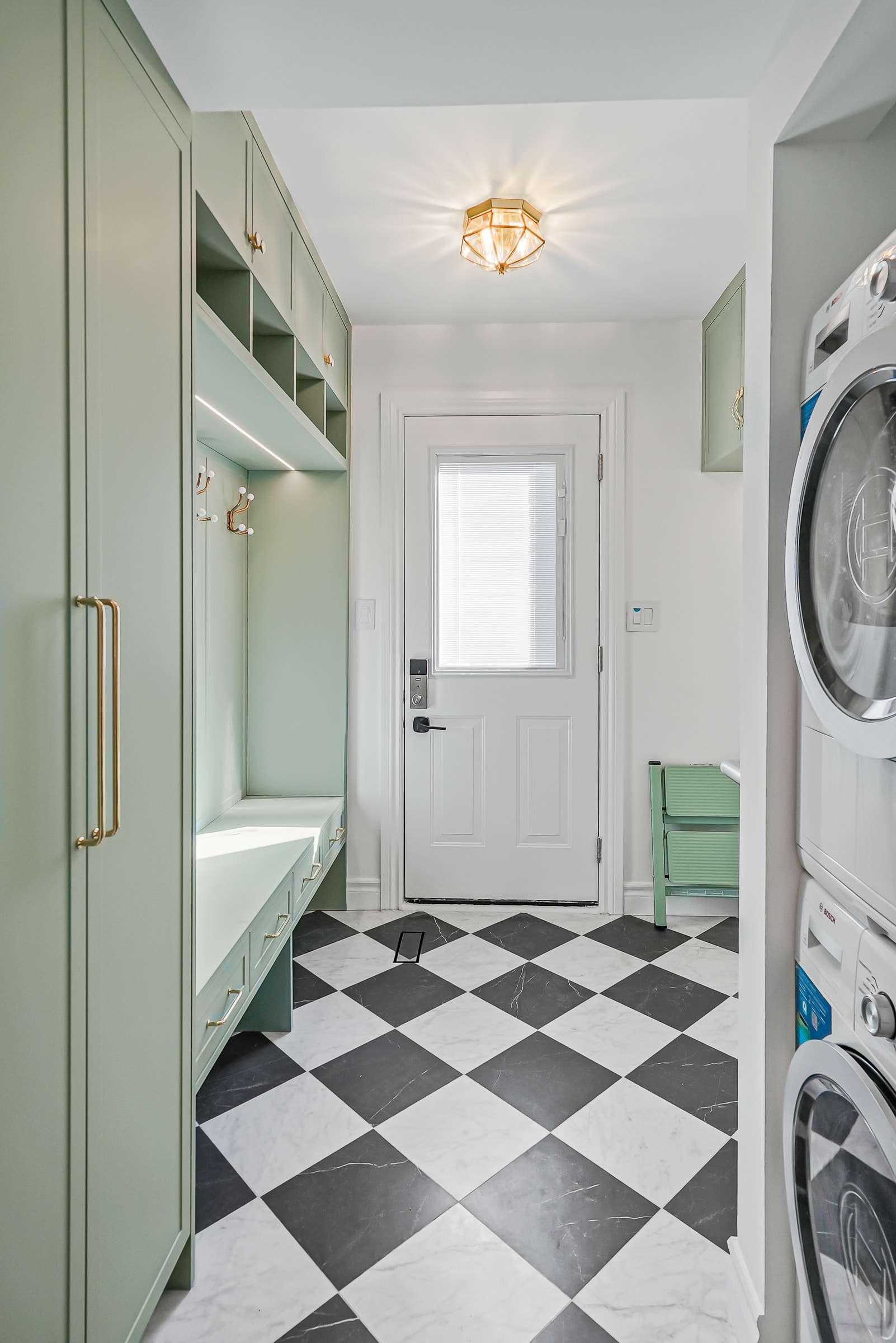 After: sage lockers and a bench along one side, the washer and dryer still on the other.